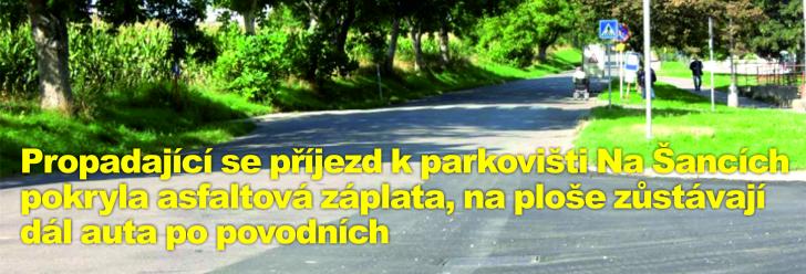 Propadající se příjezd k parkovišti Na Šancích pokryla asfaltová záplata, na ploše zůstávají dál auta po povodních